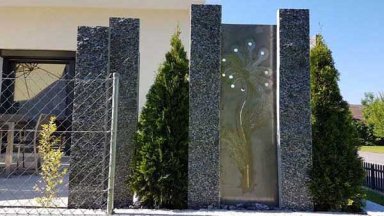 Sichtschutz aus Stein und Metall mit Pflanzen kombiniert